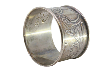 Argola de guardanapo em prata com motivos florais relevados envolvendo cartela para monograma.